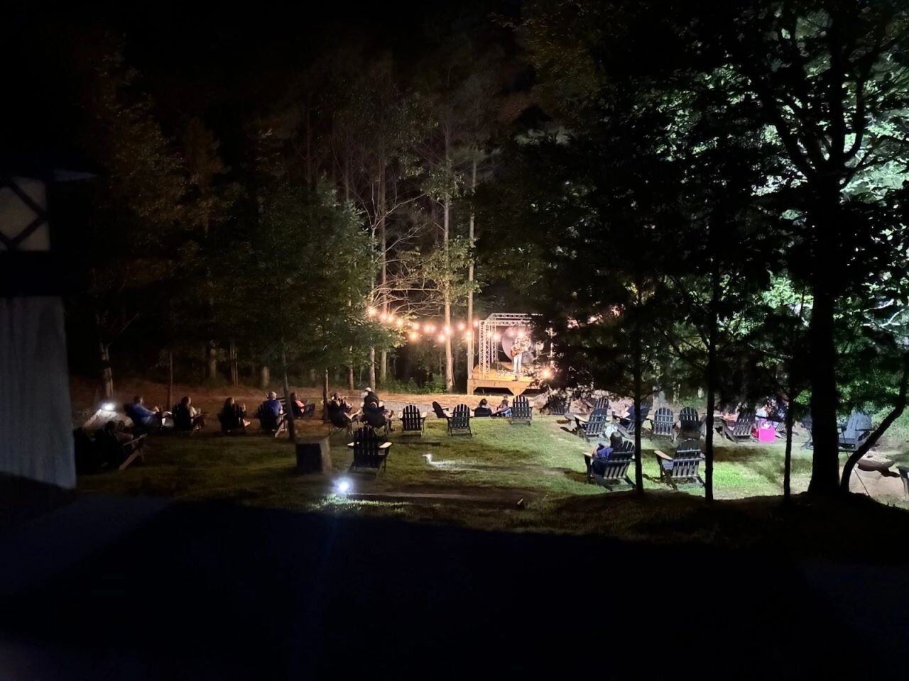 Guests gathered for a live concert on the stage at Sasquatch Farm RV Park at night