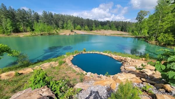 Squatch Falls, a man-made stone-edged recirculating swimming pool built into the shoreline at Vic and Vi's Bay, Sasquatch Farm RV Park